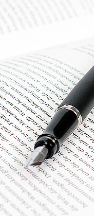 Immagine simbolica: penna sopra una pagina con testo